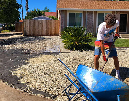 Shoveling rock from a wheel barrow